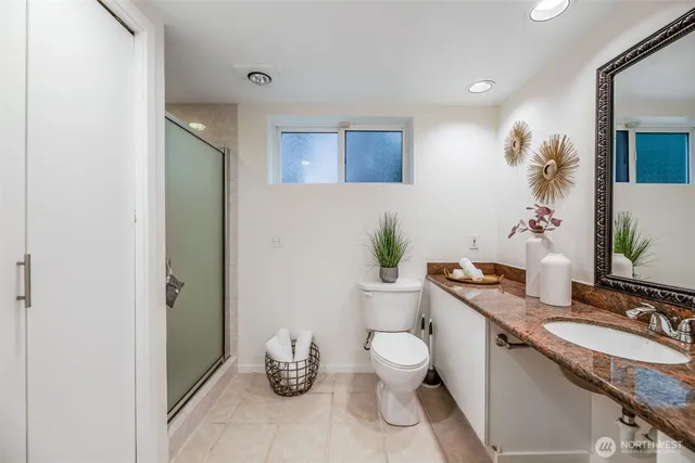 a spacious bathroom with a granite countertop toilet a sink and a mirror