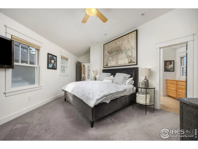 a spacious bedroom with a bed and wooden floor