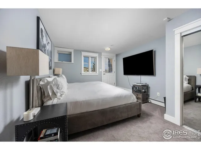 a bedroom with a bed tv and a window