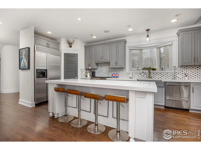 a kitchen with stainless steel appliances granite countertop a sink refrigerator and cabinets