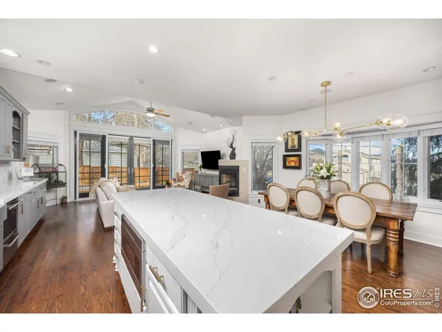 a large white kitchen with lots of counter space dining table and stainless steel appliances