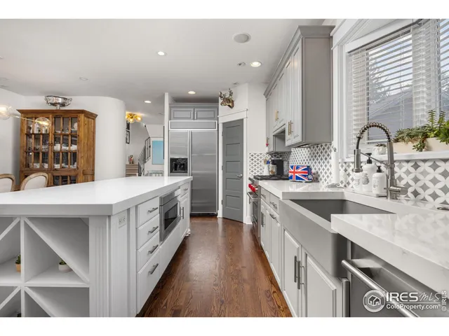 a large kitchen with a lot of counter space and wooden floor