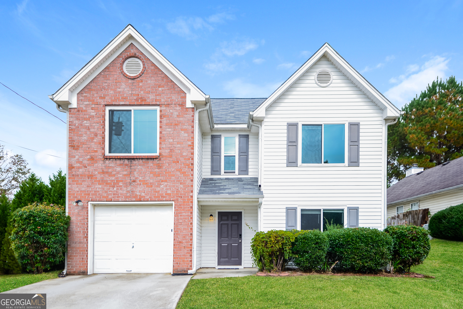 6796 Browns Mill Walk Lithonia, GA 30038 - Photo 1 of 1 a front view of a house with a yard and garage