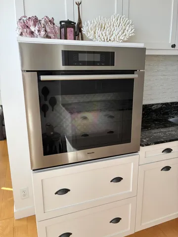 a kitchen with white cabinets and appliances