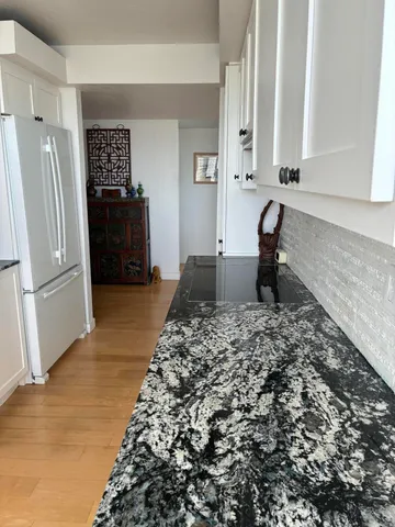 a view of a refrigerator in kitchen and a window