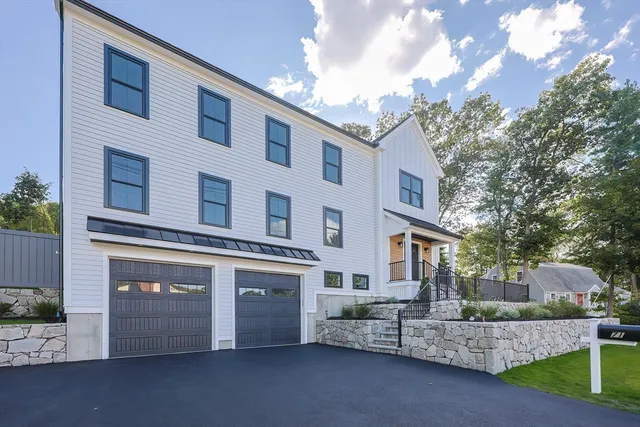 a front view of a building with a yard and garage