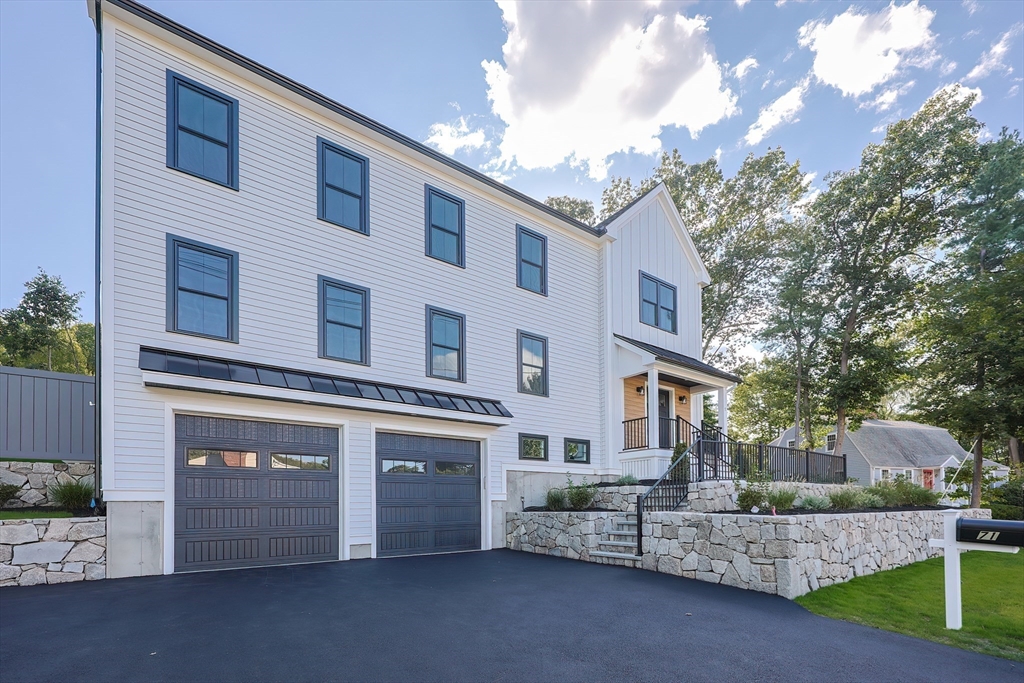 a front view of a building with a yard and garage