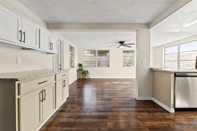 a kitchen with granite countertop a refrigerator and a stove top oven