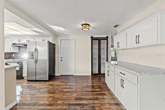 a kitchen with stainless steel appliances granite countertop a refrigerator and a stove
