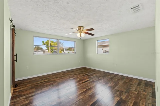 a view of empty room with wooden floor
