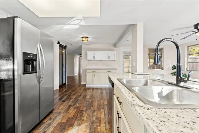 a kitchen with stainless steel appliances granite countertop a refrigerator and a sink