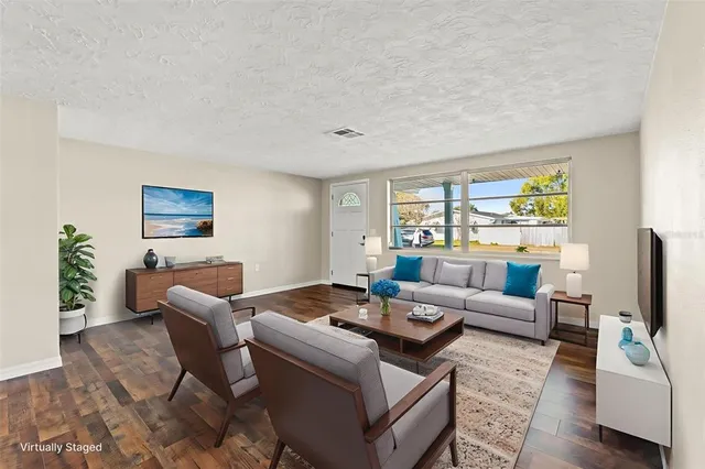 a living room with furniture flat screen tv and window