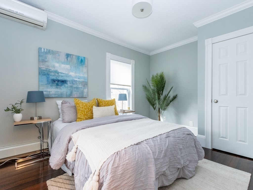 31 Gorham Street, Unit B Somerville, MA 02144 - Photo 14 of 36 a bedroom with a large bed and a potted plant