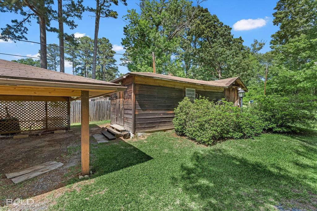 225 Marie Road Ringgold, LA 71068 - Photo 11 of 40 Carport with lattice screening, adjacent to a wood-sided outbuilding