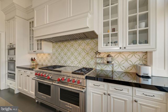 a kitchen with granite countertop white cabinets and stainless steel appliances