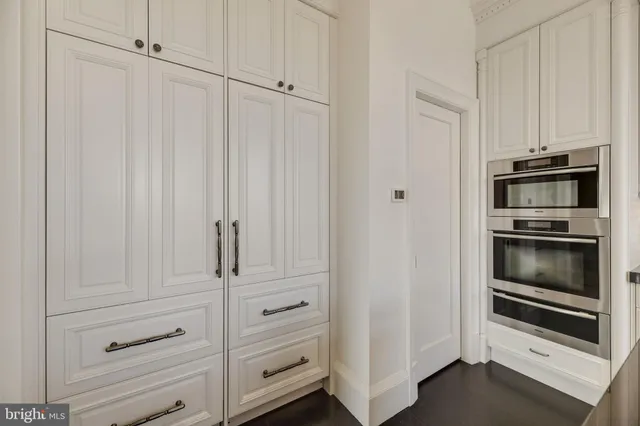 a kitchen with white cabinets and stainless steel appliances