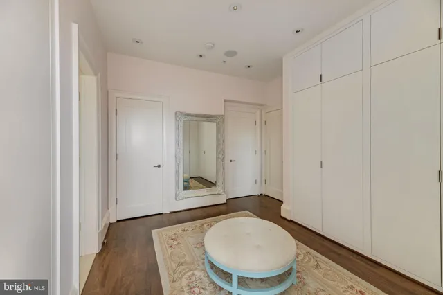 a bathroom with a granite countertop sink a mirror and a toilet
