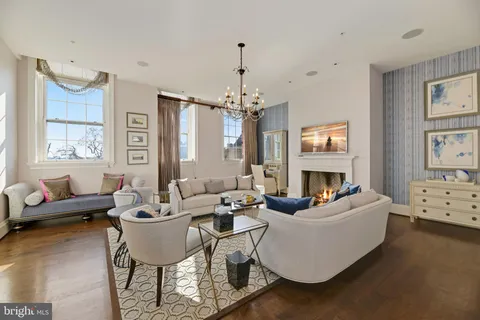a living room with fireplace furniture and a large window