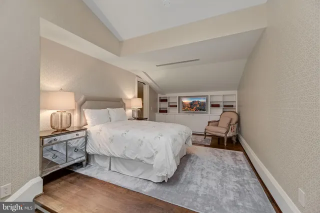 a spacious bedroom with a bed and a lamp