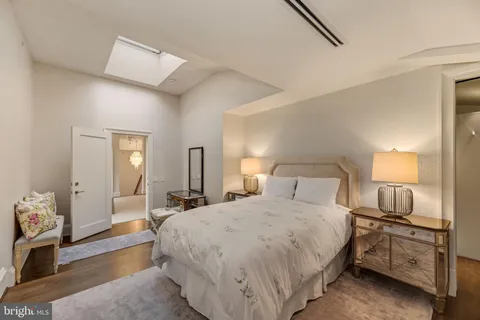 a large bedroom with a bed and wooden floor