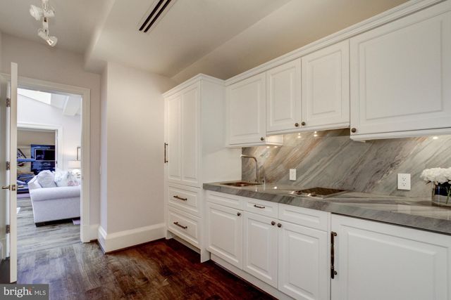 a kitchen with granite countertop a white cabinets and white appliances