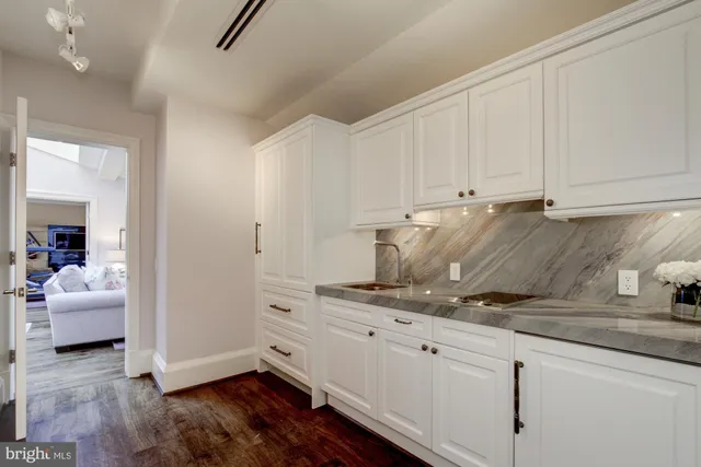 a kitchen with granite countertop a white cabinets and white appliances