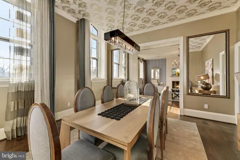 a dining room with a wooden table and chairs