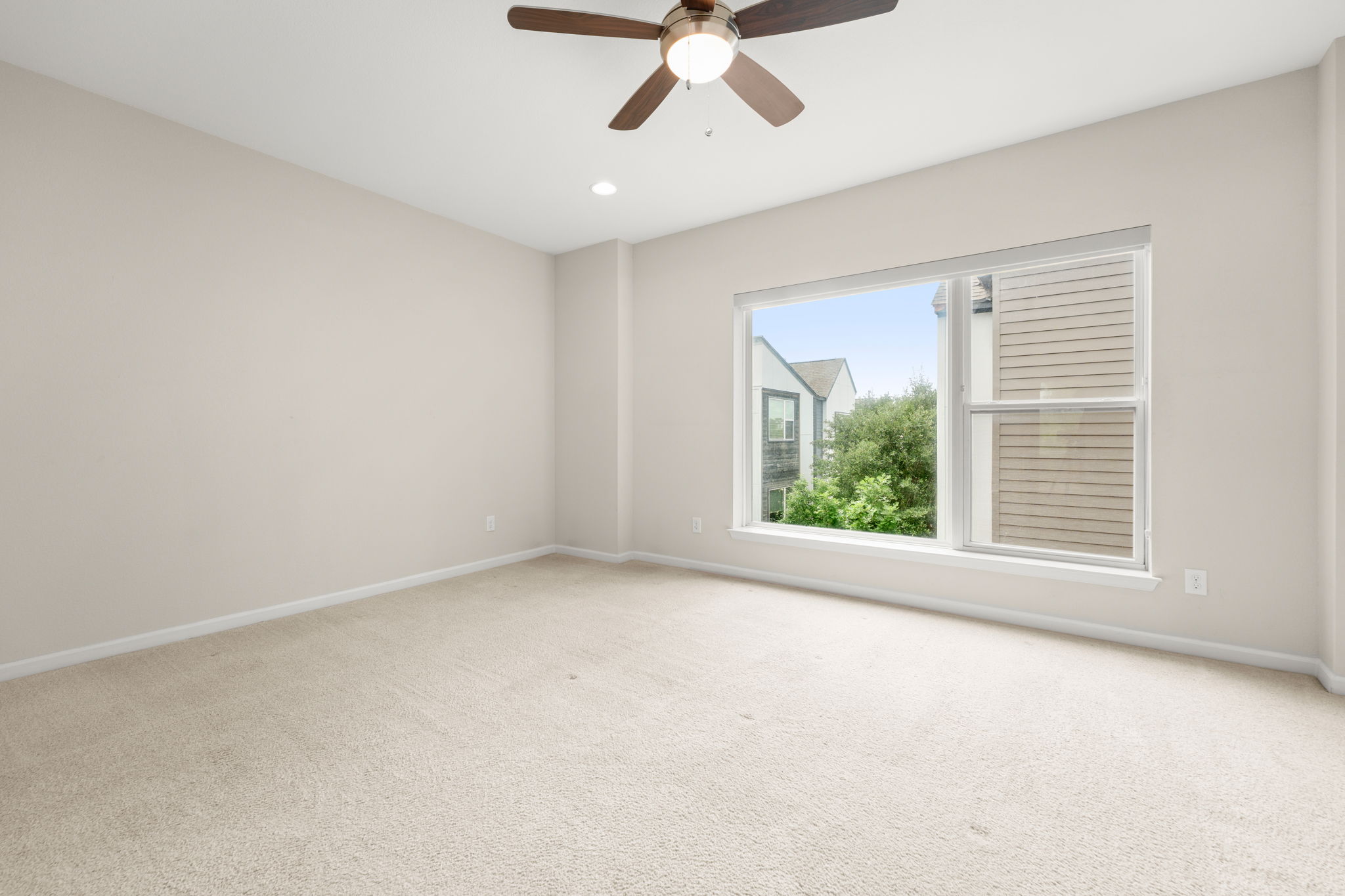 4403 Swift Path Austin, TX 78741 - Photo 12 of 32 Bright room featuring a large window, neutral carpeting, light-toned walls, a ceiling fan, and recessed lighting