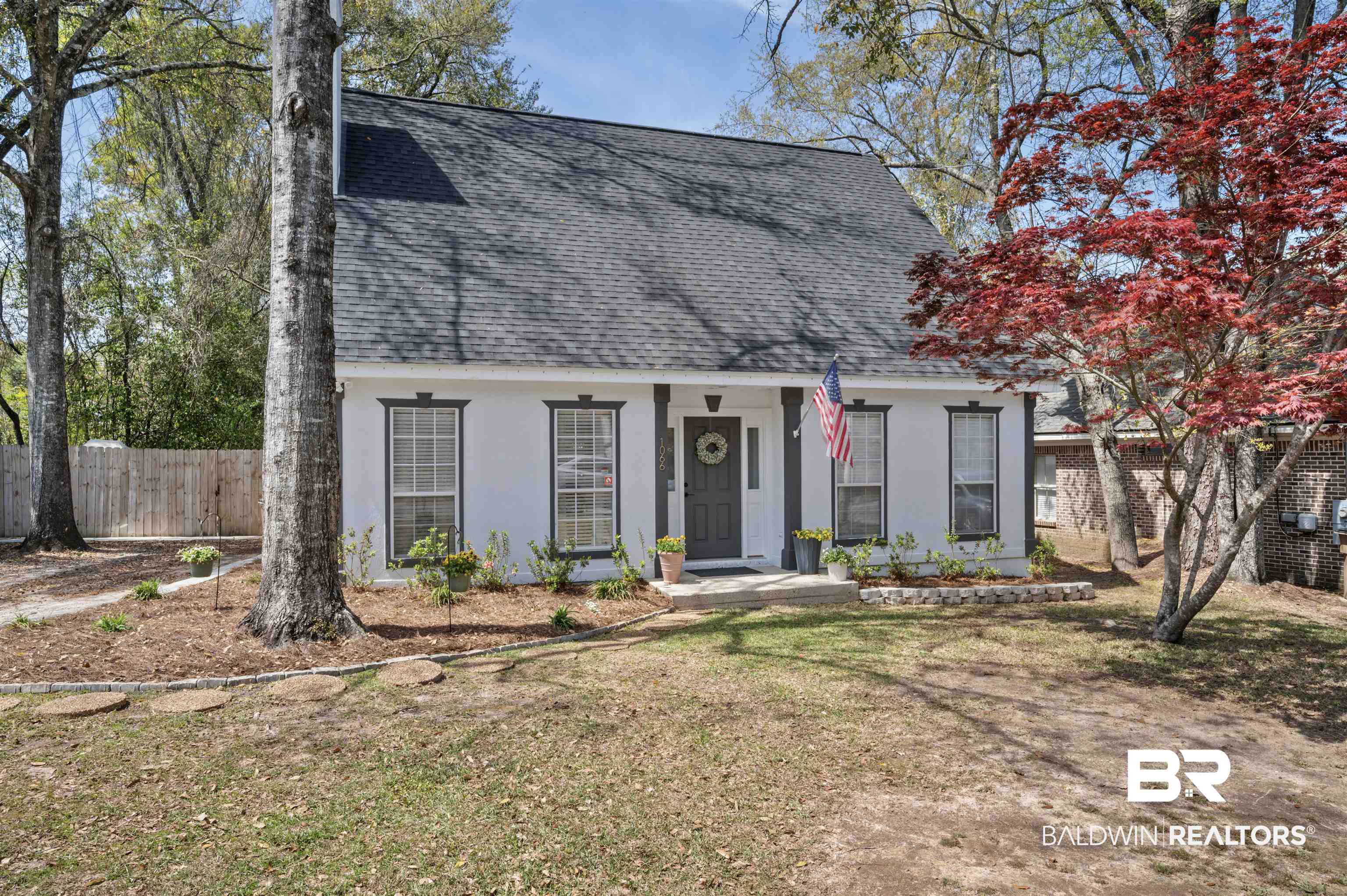 1066 Linlen Avenue Mobile, AL 36609 - Photo 1 of 22 New england style home featuring a front lawn, a shingled roof, fence, and stucco siding