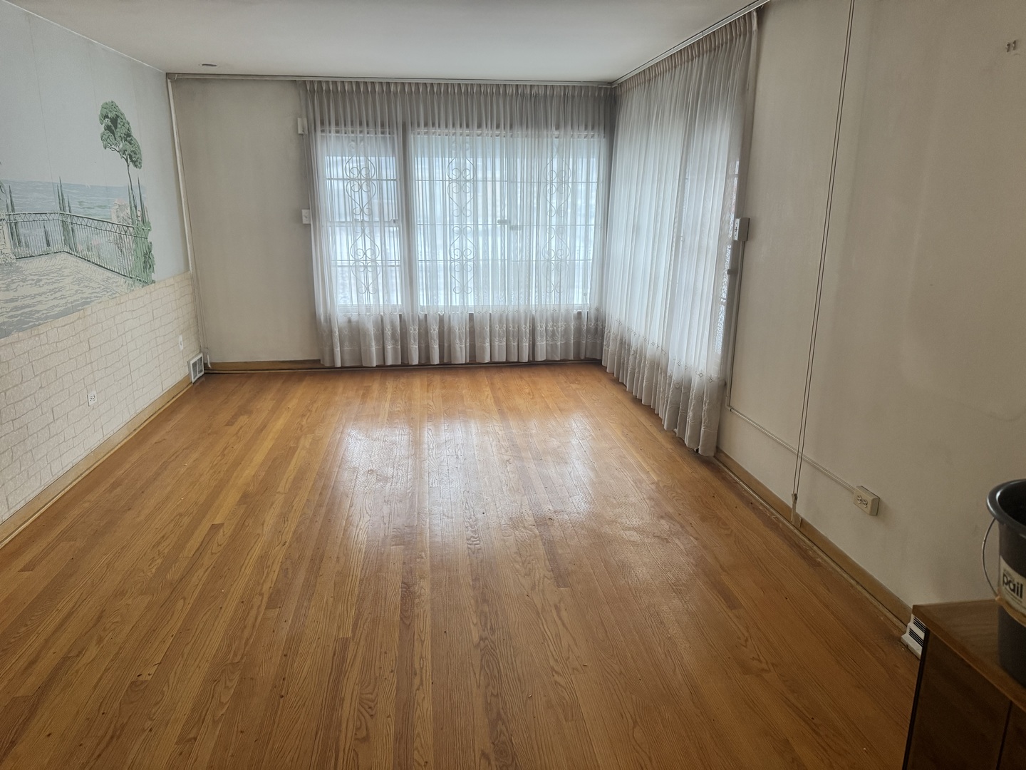 8900 South Prairie Avenue Chicago, IL 60619 - Photo 3 of 18 an empty room with wooden floor and windows