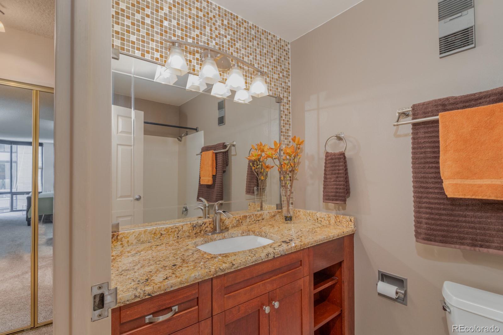 1625 Larimer Street, Unit 801 Denver, CO 80202 - Photo 12 of 33 a bathroom with a granite countertop sink and a mirror