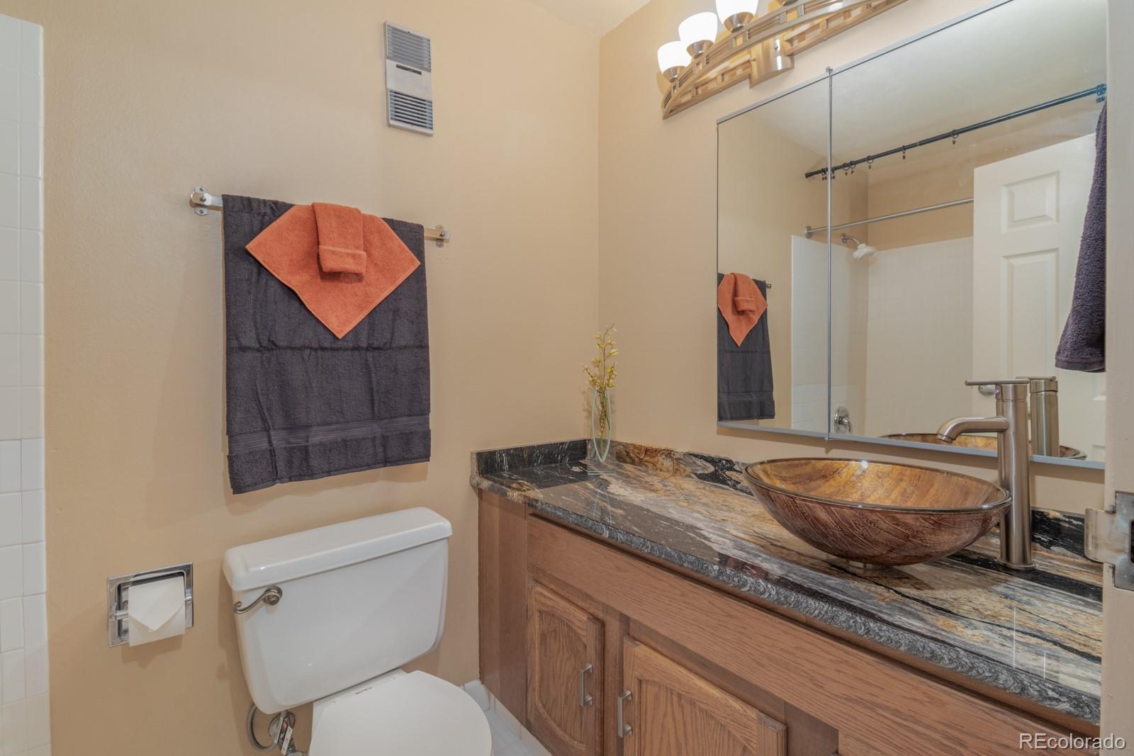 1625 Larimer Street, Unit 801 Denver, CO 80202 - Photo 16 of 33 a bathroom with a granite countertop toilet sink and mirror