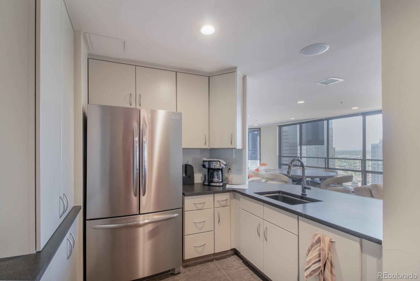 1625 Larimer Street, Unit 801 Denver, CO 80202 - Photo 25 of 33 a kitchen with stainless steel appliances a refrigerator sink and cabinets