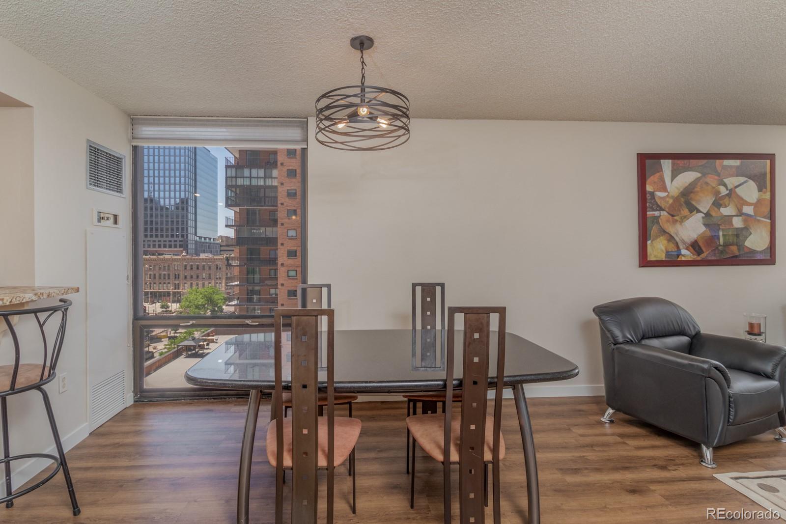 1625 Larimer Street, Unit 801 Denver, CO 80202 - Photo 4 of 33 a view of a dining room with furniture wooden floor and a chandelier