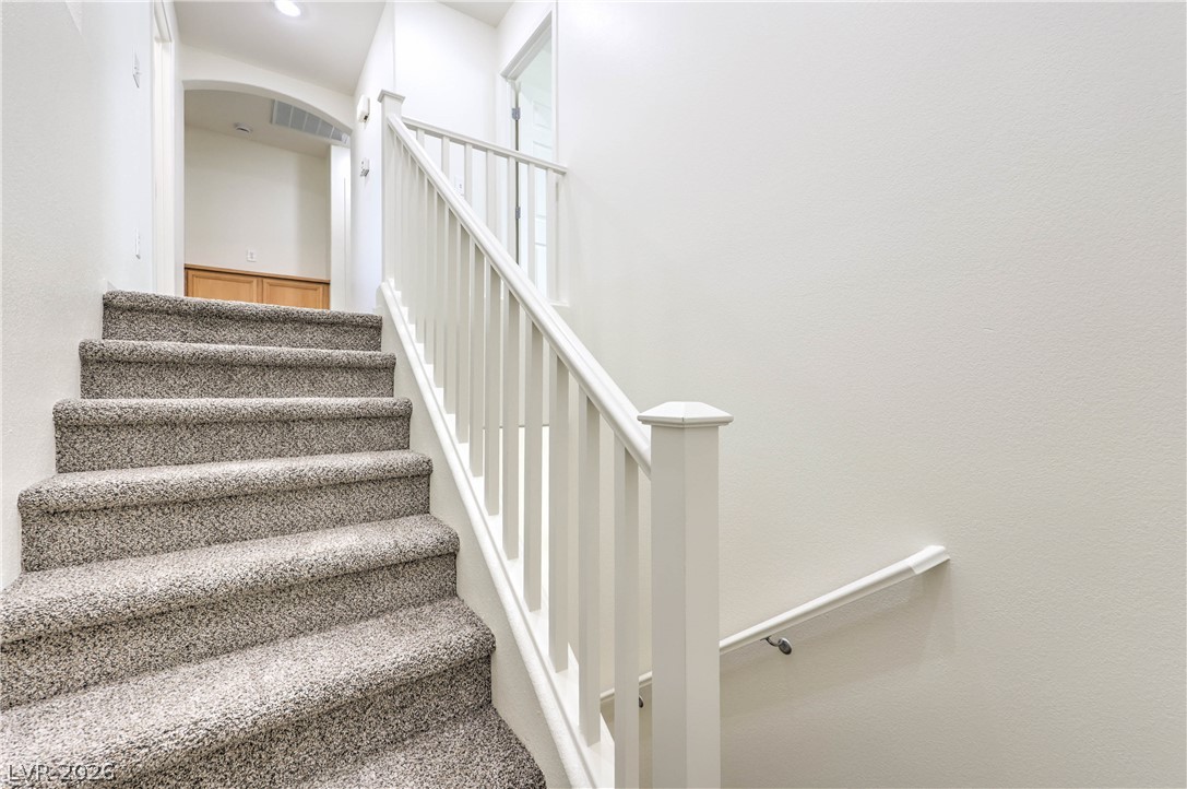 10939 Paradise Road Henderson, NV 89052 - Photo 19 of 36 A well-lit stairway with soft, inviting carpet leads to the upper level.