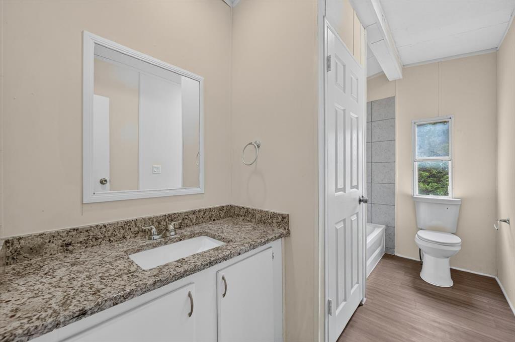 13405 Wheat Road Venus, TX 76084 - Photo 22 of 32 Bathroom featuring a vanity with a stone-finish countertop, undermount sink, and polished chrome faucet