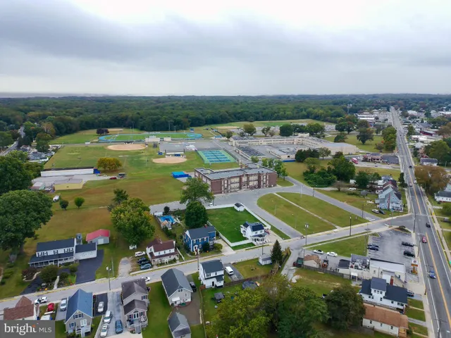 an aerial view of a city with lots of residential buildings and ocean view in back