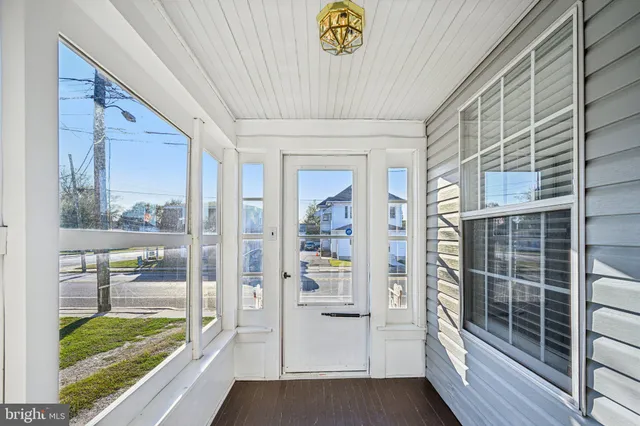 a view of a hallway with wooden floor and windows