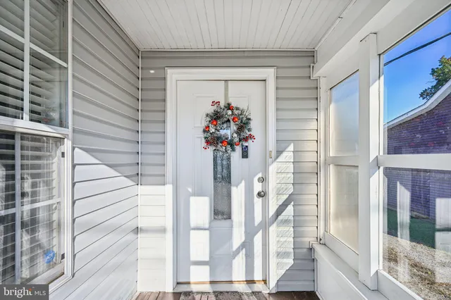 a view of a hallway with wooden floor and windows
