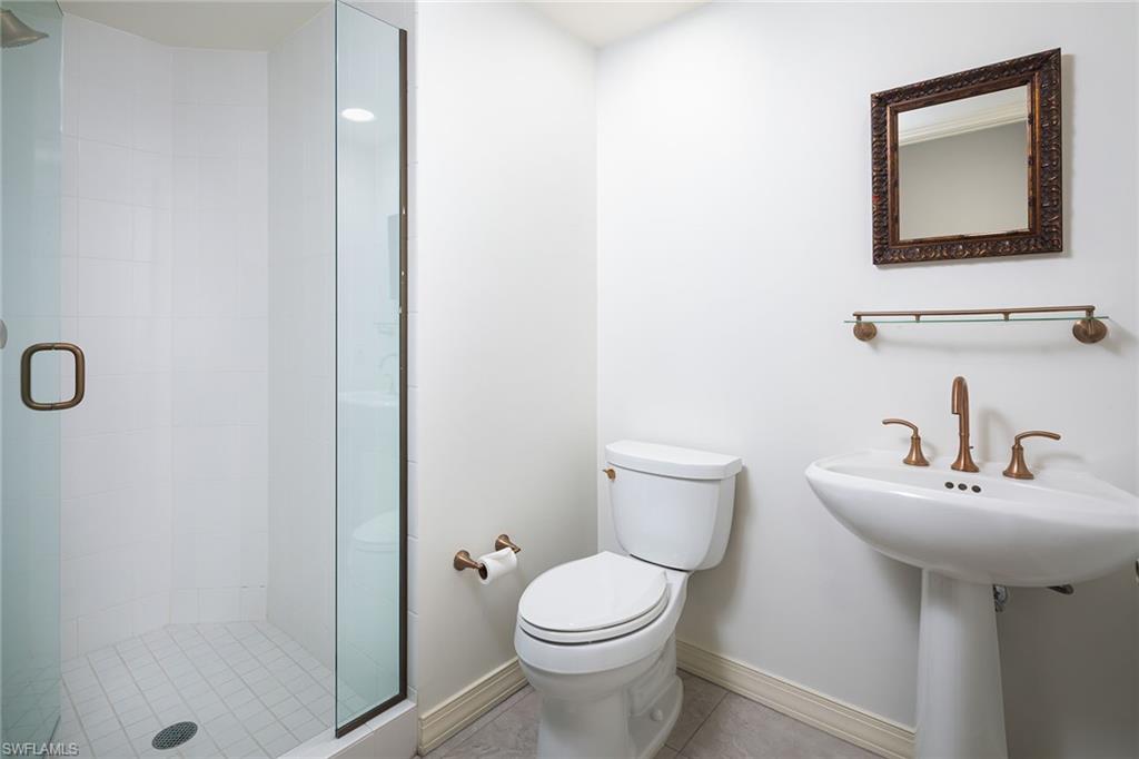435 Dockside Drive, Unit B703 Naples, FL 34110 - Photo 23 of 38 a bathroom with a toilet sink and mirror