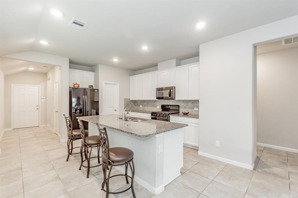 21423 Holly Heights Road Cypress, TX 77433 - Photo 4 of 12 a kitchen with stainless steel appliances kitchen island granite countertop a refrigerator and cabinets