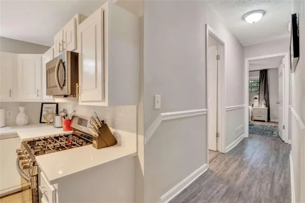 a kitchen with white cabinets and wooden floor