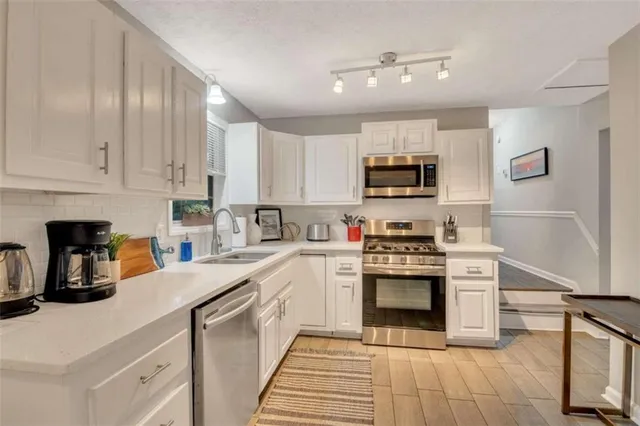 a kitchen with stainless steel appliances granite countertop a stove and white cabinets