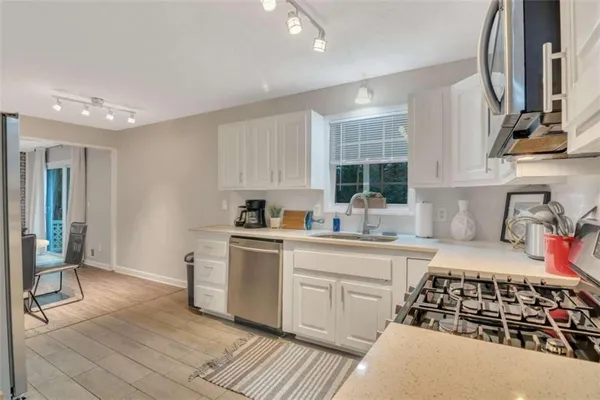 a kitchen with stainless steel appliances a sink stove and cabinets