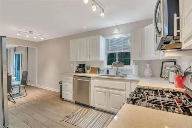 a kitchen with stainless steel appliances a sink stove and cabinets