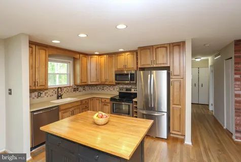 a kitchen with kitchen island granite countertop a sink refrigerator stove and microwave