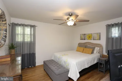 a bedroom with a bed chandelier and a window