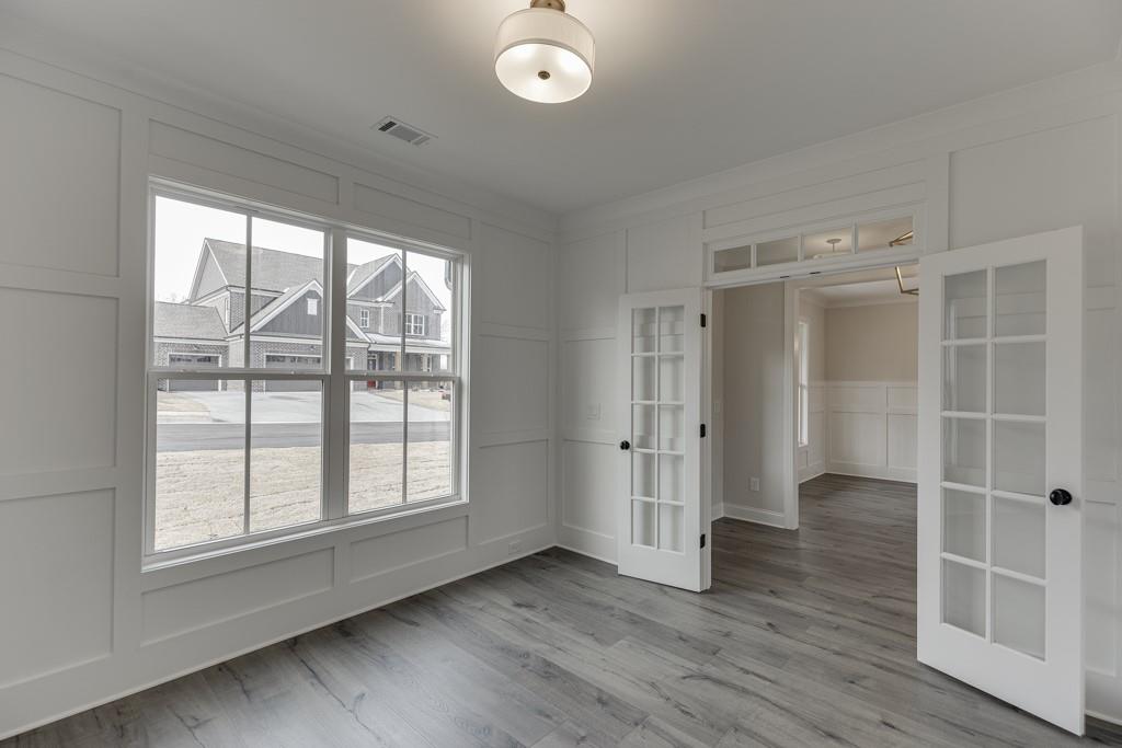 173 Swimming Pool Road Buford, GA 30518 - Photo 10 of 68 an empty room with wooden floor and windows