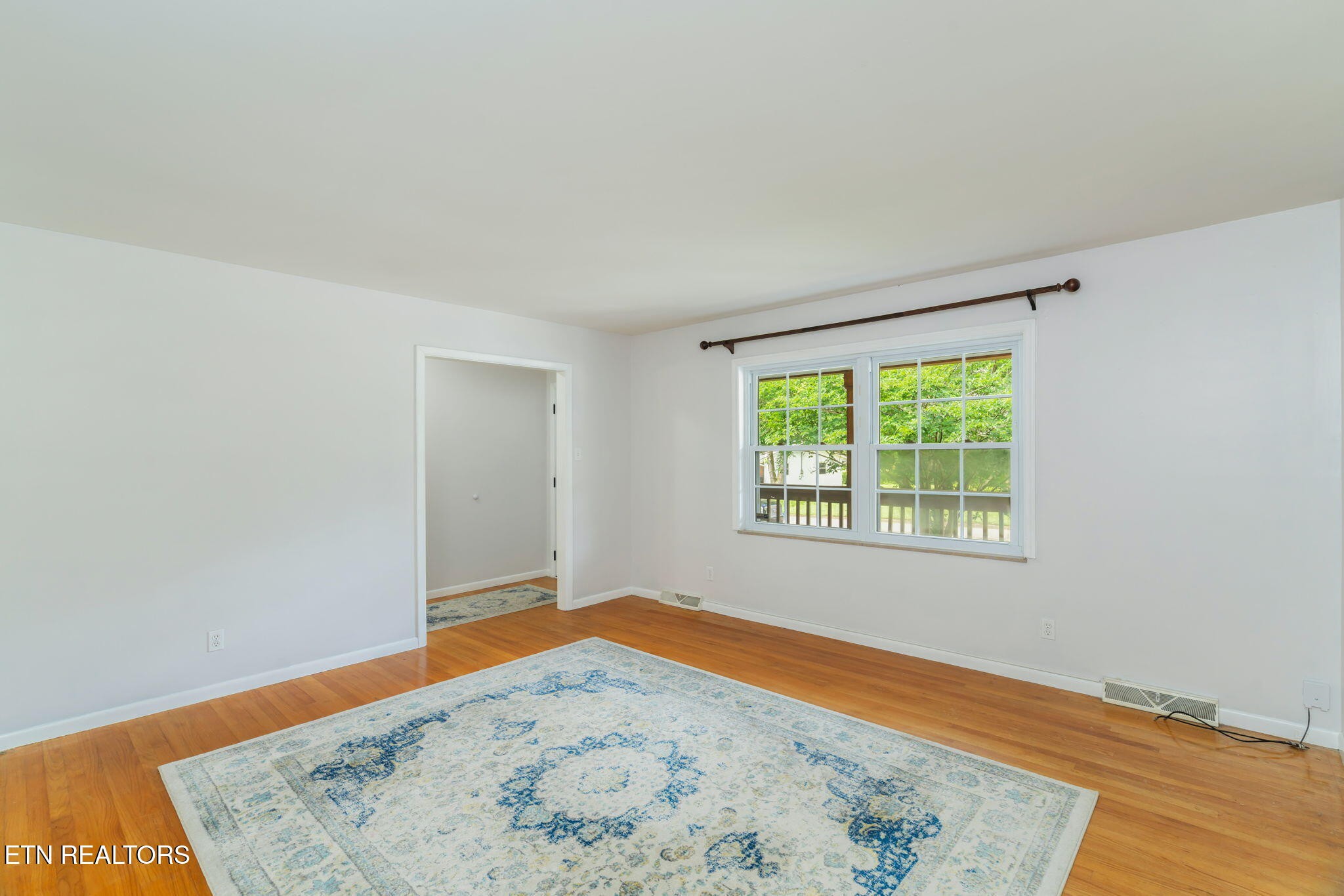 824 Noragate Road Knoxville, TN 37919 - Photo 7 of 29 an empty room with wooden floor and window