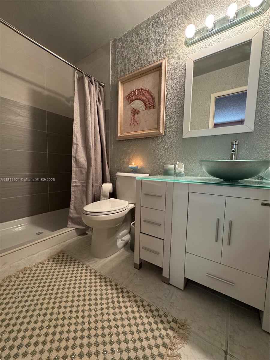 10428 Northwest 3rd Street Pembroke Pines, FL 33026 - Photo 16 of 30 a bathroom with a sink a toilet and a mirror